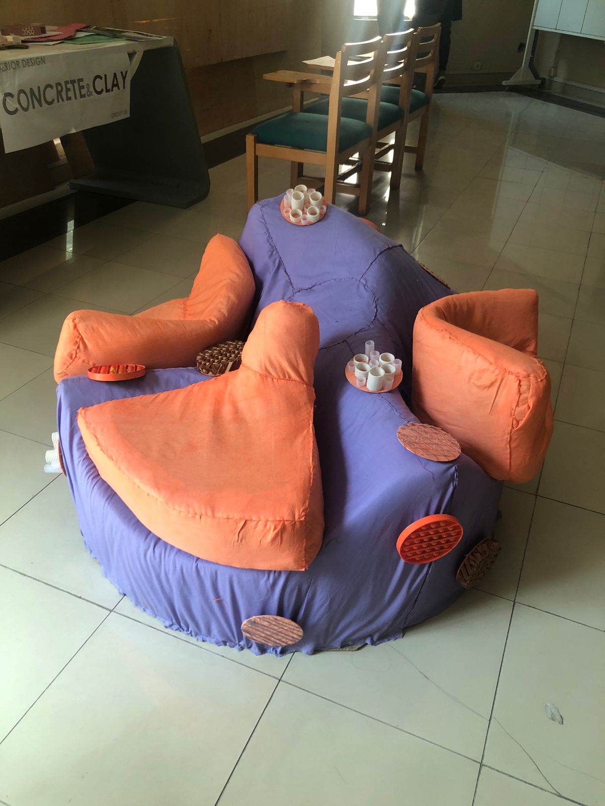 The finished Globy seat in a studio room, next to adult chairs